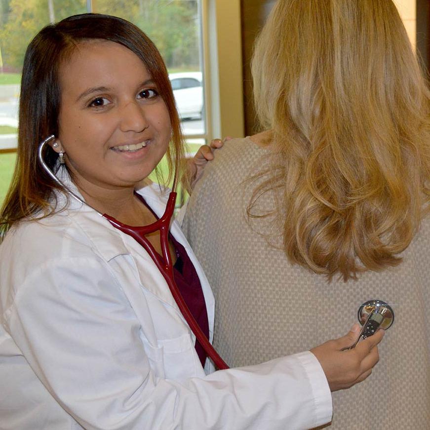 一位健康科学专业的学生戴着助听器，使用听诊器  